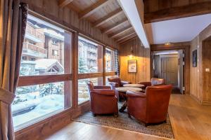 a room with a table and chairs and a large window at Hotel Kandahar in Val dʼIsère