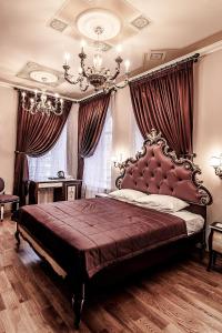 een slaapkamer met een groot bed en een kroonluchter bij Art Hotel Aleksandrovsky in Kostroma