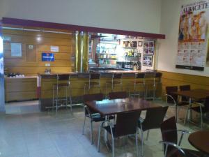 a restaurant with tables and chairs and a bar at Hotel Cardinal in Albacete