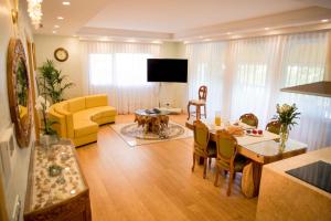 sala de estar con mesa y sofá amarillo en Eco Geo Sol, en Lloret de Mar
