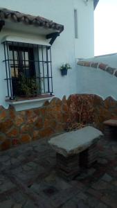eine Steinbank vor einem Gebäude mit einem Fenster in der Unterkunft Las 4 Lunas in Zahara de la Sierra