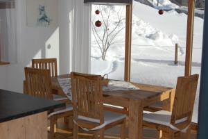 a dining room with a wooden table and chairs at Appartements Christine in Bezau