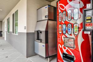 una máquina de refrescos en un edificio con dispensador de bebidas en Palace Inn Blue Tomball Parkway en Houston