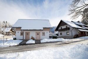 una casa blanca con nieve en el suelo en Apartments Alp, en Bohinj