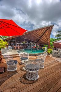 a deck with chairs and an umbrella and a pool at Deco Stop Lodge in Luganville