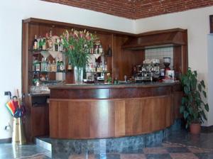 a bar in a restaurant with a vase of flowers at Albergo Antica Dogana in Asti