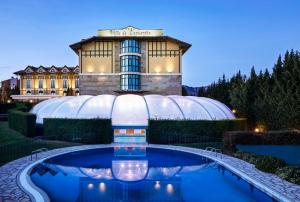 een gebouw met een zwembad voor een gebouw bij Hotel Silken Villa de Laguardia in Laguardia