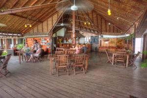 a group of people sitting at tables in a restaurant at Deco Stop Lodge in Luganville