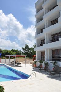 a hotel with a swimming pool in front of a building at Hotel Isla Verde in Tubará