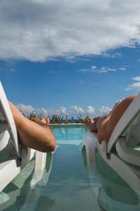 a person laying on the edge of a swimming pool at Anah Suites in Playa del Carmen