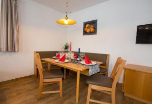 a dining room with a wooden table and chairs at Appartements Romantika & Appartement Barbara in Wagrain