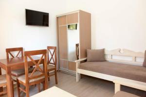 a small room with a bed and a table and chairs at Sunny Suites in Maleme