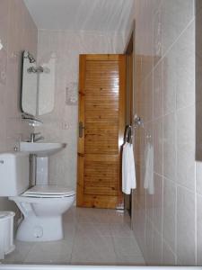 
a bathroom with a toilet a sink and a shower at Hotel Santa María in Palos de la Frontera
