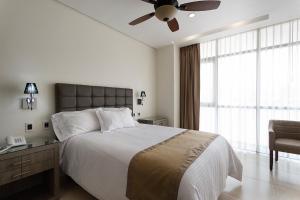 1 dormitorio con 1 cama grande y ventilador de techo en Hotel Maria Fernanda Inn, en Zitácuaro