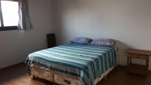 a bedroom with a bed with a blue and white blanket at Apartamento La Plata in La Plata