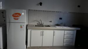 a kitchen with a sink and a white refrigerator at Apartamento La Plata in La Plata