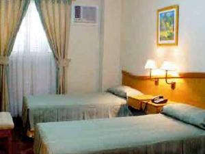 Llit o llits en una habitació de Alcor Hotel