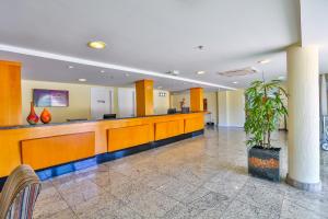 a lobby with a waiting area with a potted plant at Dubai Macaé by Atlântica in Macaé +67 photos