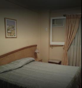 1 dormitorio con cama y ventana en Alcor Hotel en Mendoza