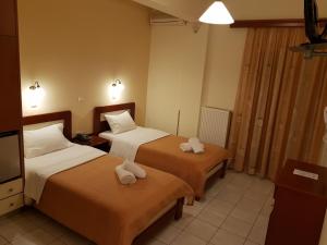 una camera d'albergo con due letti e asciugamani di Hotel Nevada Kalamata a Kalamáta