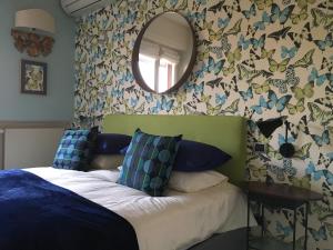デセンツァーノ・デル・ガルダにあるClorofillaのベッドルーム1室(ベッド1台、壁掛け鏡付)