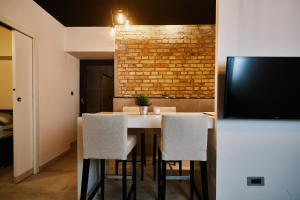 a dining room with a table and chairs and a brick wall at Apartment and Rooms Marinac in Zagreb