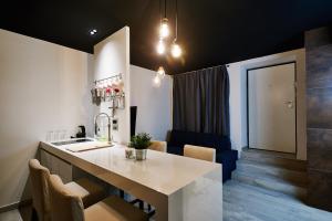 a kitchen with a counter with chairs and a sink at Apartment and Rooms Marinac in Zagreb