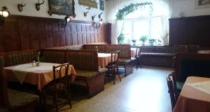 una sala da pranzo con tavoli, sedie e una finestra di Hotel zum goldenen Hirschen a Göstling an der Ybbs