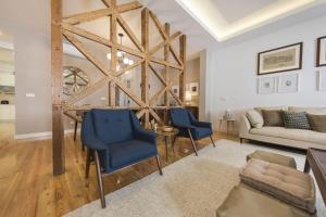 a living room with a table and blue chairs at Downtown 2Bedroom Wonder in Lisbon