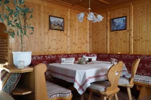 a dining room with a table and chairs and wooden walls at Landhaus Schatz in Nesselwängle