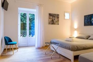 een slaapkamer met een bed, een stoel en een raam bij Kala Rooms in Palermo