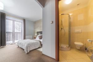 a bedroom with a bed and a shower and a toilet at Nefryt - 600 m od PKP, duży parking, lodówka, czajnik, balkon, in Karpacz