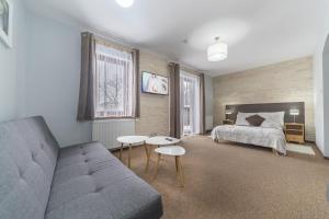 a bedroom with a bed and a couch at Nefryt - 600 m od PKP, duży parking, lodówka, czajnik, balkon, in Karpacz