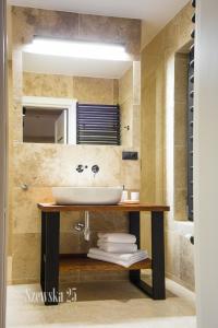 a bathroom with a sink and a mirror at Apartamenty Szewska 25 in Toruń