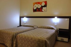 a hotel room with two beds and a painting on the wall at Hotel Boccascena in Genoa