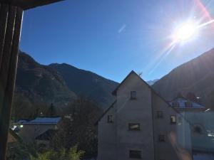 a view of a building with the sun in the sky at Appartement Duplex in Luchon