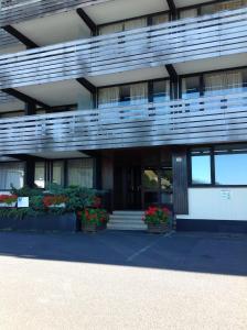 un edificio con balcones y flores delante de él en Appartement Super Besse en Super Besse