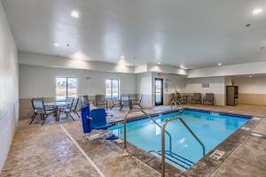 una piscina con sedie e tavolo e una sala da pranzo di Comfort Inn Altoona-Des Moines ad Altoona