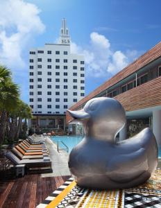 a large silver rubber duck statue sitting next to a pool at SLS South Beach in Miami Beach