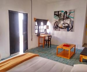 una camera con letto, tavolo e scrivania di La Tozi Hotel a San Cristóbal de Las Casas
