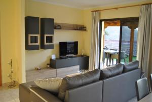 a living room with a couch and a television at Villa Sunset Tauro in Mogán