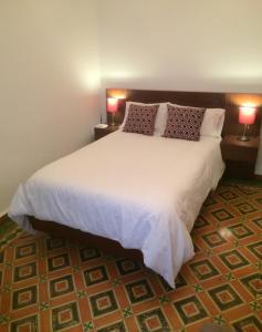 1 dormitorio con 1 cama blanca grande y 2 lámparas en Zocalo INCREIBLE en Puebla