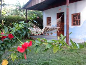 a porch with a hammock in front of a house at Rosa's Lake Cabins in Mérida