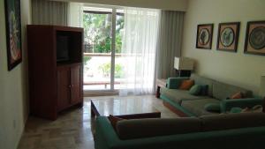 a living room with a couch and a tv at Suites at Mayan Palace Vidanta Resort Riviera Maya in Playa del Carmen