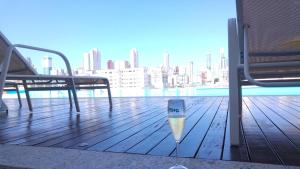 een glas wijn op een terras met uitzicht op de stad bij Home Clube em Balneário Camboriú in Balneário Camboriú