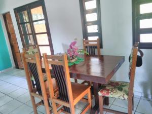 een eettafel en stoelen met bloemen erop bij Casa em Condominio Caragua in Caraguatatuba