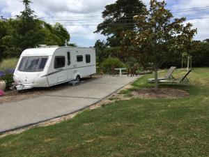 uma caravana branca estacionada ao lado de uma estrada em Silverdale Retreat em Orewa