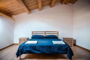 een slaapkamer met een bed met blauwe lakens en houten plafonds bij Case Vacanze - Antico Corso in Catania