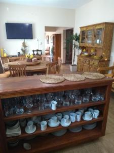 a table with cups and dishes on a shelf at Frente a Praia. Ótima casa barra de são João Rio das ostras,fino acabamento in Barra de São João