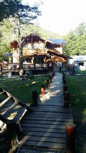 een houten loopbrug met banken in een park bij Posada del Valle in Ushuaia